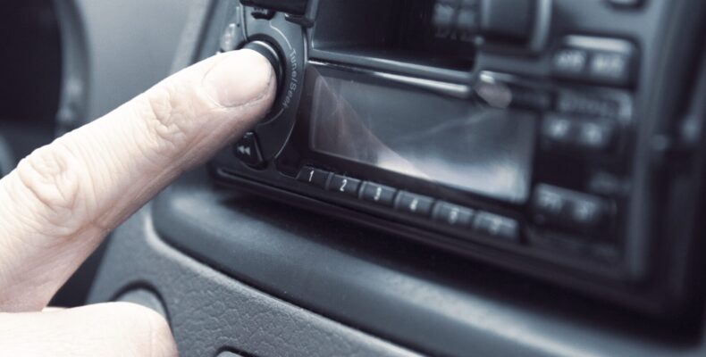 Radio in your marketing mix - person selecting a radio station in a car