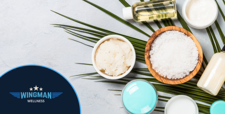 mental health - sugar scrub, cream, essential oils sitting on a palm leaf